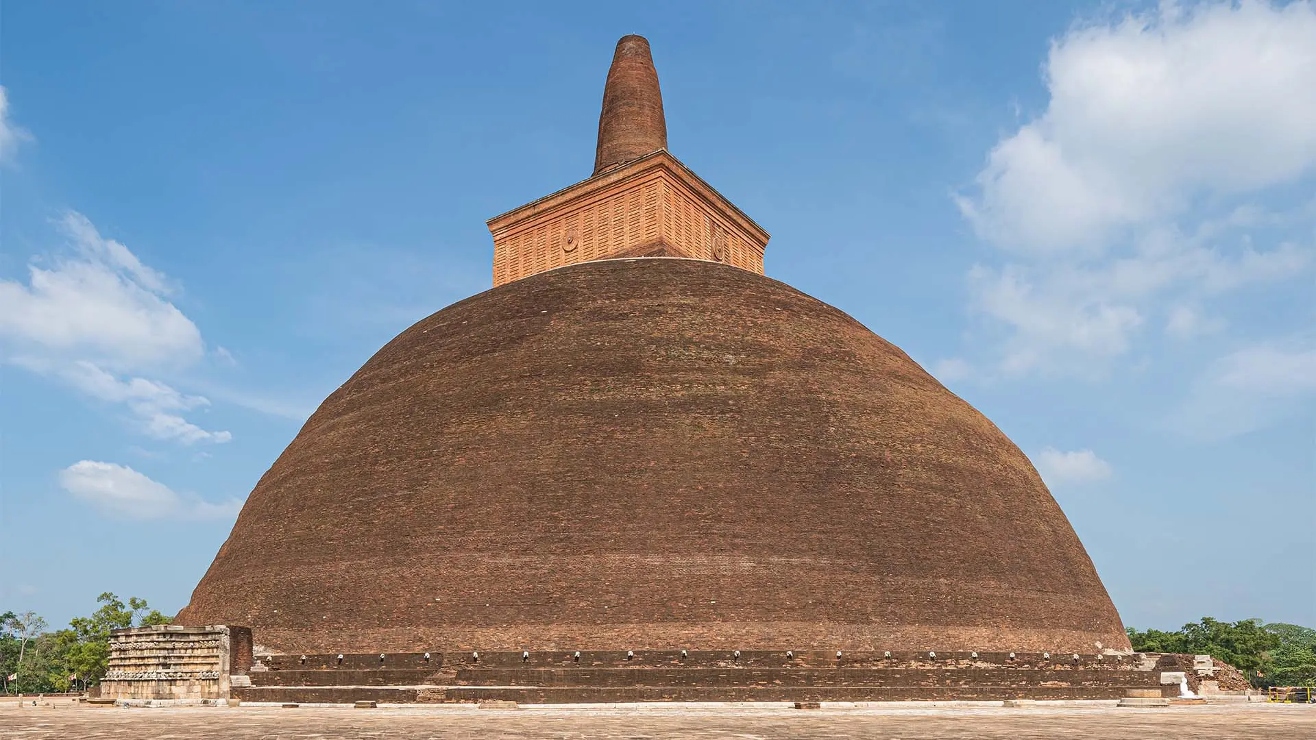 Ancient Abhayagiriya stupa under a clear blue sky.