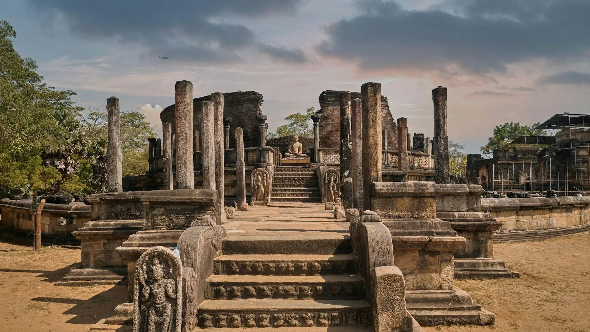 Ancient Polonnaruwa Vatadage with intricate stone architecture and central stupa amidst lush greenery.